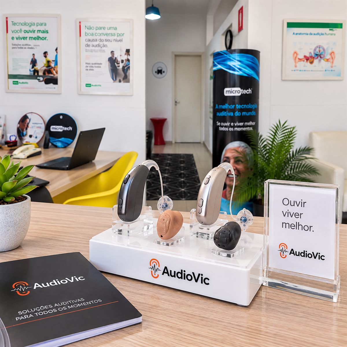 Expositor da AudioVic com diferentes tipos de aparelho auditivo em exposição, ao lado do material da loja