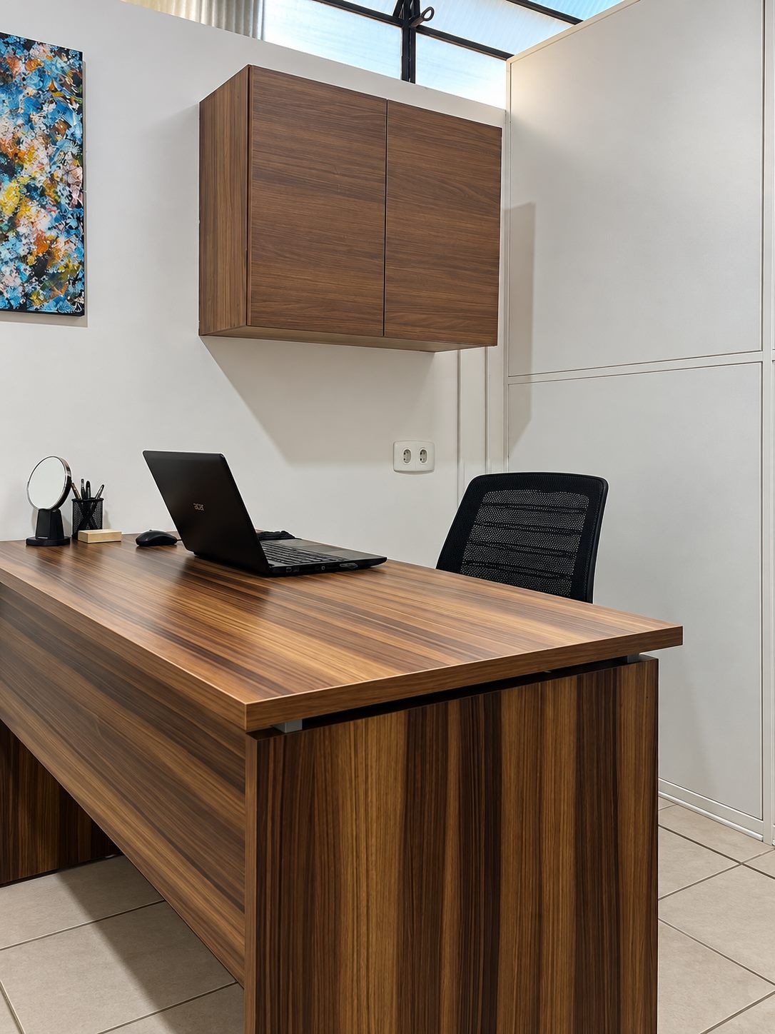 Sala de atendimento da AudioVic, com mesa de madeira e cadeiras para quem é atendido e para o acompanhante